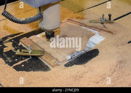 Fresatrice cnc automatizzata per il taglio di pezzi in legno dalla pasta di legno. Lavorazione del legno, incisione, intaglio, industriale Foto Stock