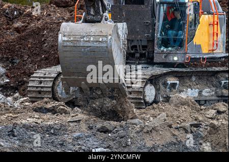 Benna dell'escavatore in vista ravvicinata, scarico del terreno Foto Stock