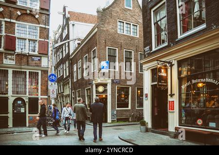 Gente che cammina a Zeedijk, una strada nel centro storico di Amsterdam. La strada è il confine settentrionale e orientale di De Wallen. Famoso con molti bar Foto Stock