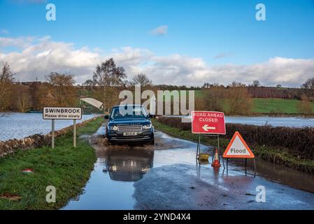 Oxfordshire, 25 novembre 2024. Un'auto 4x4 negozia una strada allagata nell'Oxfordshire. Crediti: Martin Anderson/Alamy Live News Foto Stock