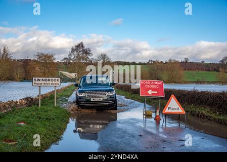 Oxfordshire, 25 novembre 2024. Un'auto 4x4 negozia una strada allagata nell'Oxfordshire. Crediti: Martin Anderson/Alamy Live News Foto Stock