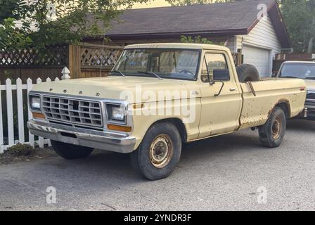 Calgary, Alberta, Canada. 21 luglio 2024. Un'assolata scena suburbana con un pick-up giallo Un modello Ford F-Series Ranger parcheggiato nel vialetto di una nea Foto Stock