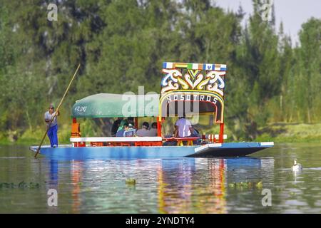 Città del Messico, Messico. 11 gennaio 2024. Una vista laterale di una Trajinera, una barca in stile gondola che scivola lungo i canali di Xochimilco, con turisti che si godono Foto Stock