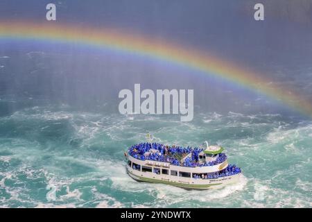 Niagara, Ontario, Canada. 7 giugno 2023. Turisti in gita in barca alle Cascate del Niagara in estate, con un arcobaleno che emerge dalla nebbia d'acqua Foto Stock