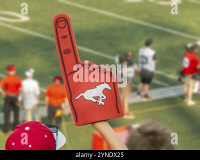 Calgary, Alberta, Canada. 21 luglio 2024. Un ventilatore che regge un dito in schiuma rossa con il logo Calgary Stampeders, esultante Foto Stock