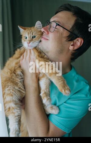 Il veterinario curante coccola un gatto di zenzero in una clinica accogliente, mostrando amore e compassione nella salute degli animali Foto Stock