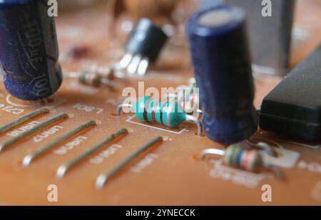 Componenti elettronici montati su una scheda a circuito stampato. Incentrato sull'induttore assiale verde. Foto Stock