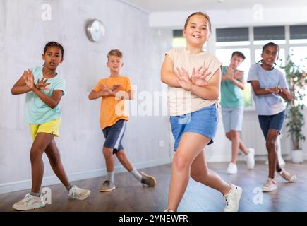 Sorridente tra una ragazza che impara danze dinamiche moderne in una lezione di coreografia Foto Stock