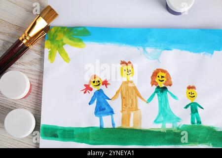 Disegno per bambini di una famiglia felice e provviste su un tavolo in legno, vista dall'alto Foto Stock