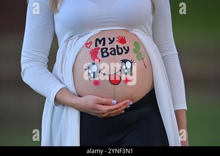 Schwangere Frau zeigt ihren nacken Baby Bauch, der mit bunten Aufklebern bedeckt ist. IL MIO BAMBINO *** donna incinta mostra il suo collo la pancia del bambino ricoperta di adesivi colorati IL MIO BAMBINO Foto Stock