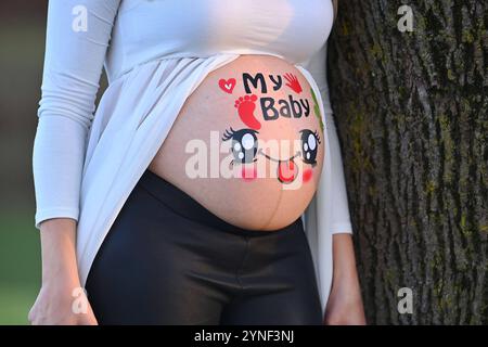 Schwangere Frau zeigt ihren nacken Baby Bauch, der mit bunten Aufklebern bedeckt ist. IL MIO BAMBINO *** donna incinta mostra il suo collo la pancia del bambino ricoperta di adesivi colorati IL MIO BAMBINO Foto Stock