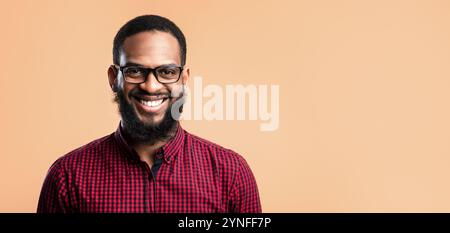 Sorridente afro uomo che posa su sfondo giallo Foto Stock