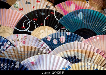 Uno schema di diversi fan giapponesi pieghevoli colorati, o "sensu" visto in una vetrina di negozi a Kyoto, in Giappone. Foto Stock