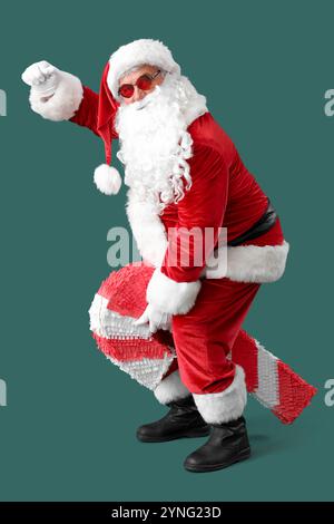 Babbo Natale fresco con pinata di canna caramella su sfondo verde Foto Stock