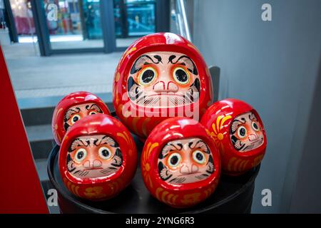 Questa vivace immagine mostra una collezione di bambole Daruma giapponesi tradizionali, con i loro corpi rossi distintivi, gli occhi bianchi e determinati espressivi Foto Stock