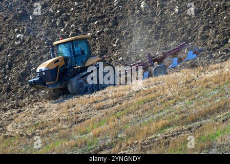 TOSCANA, ITALIA - 23 SETTEMBRE 2017: Aratura trattore su un terreno collinare Foto Stock