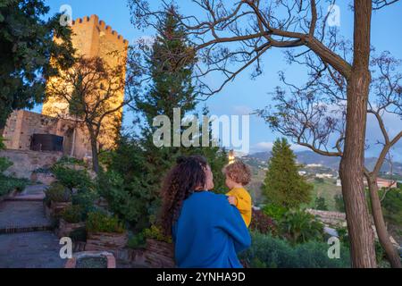 Madre con bambino in visita a un'antica fortezza musulmana al tramonto durante un tour panoramico Foto Stock