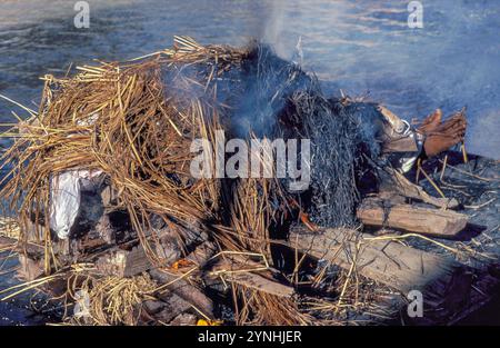 India, Varanasi, Benares, cremazione rituale sul Manikarnika Ghat sul fiume Gange. Foto Stock