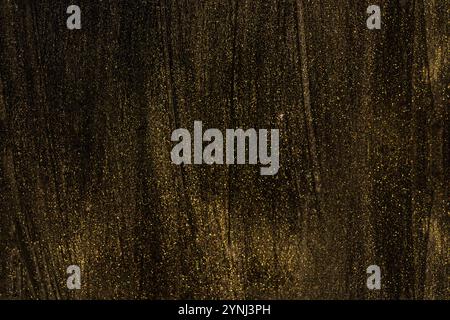 Vernice oro brillante su texture nera Foto Stock