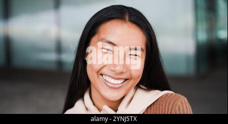 Ragazza asiatica che sorride sulla macchina fotografica durante l'inverno all'aperto - ritratto di donna giapponese - concetto di stile di vita femminile e bellezza - Focus sul viso Foto Stock