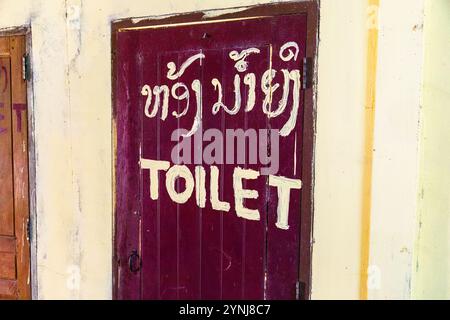 Insegna dipinta a mano sulla porta di legno di un bagno a Vang Vieng, nel Laos settentrionale, nel sud-est asiatico Foto Stock