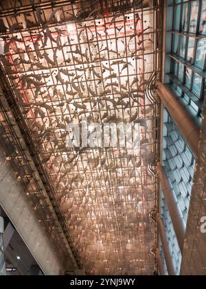 Soffitti dal design moderno e complesso con motivi astratti ed elementi metallici in uno spazio architettonico contemporaneo Foto Stock