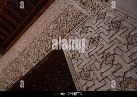 Intricati motivi geometrici e floreali scolpiti nelle pareti dei Palazzi Nasridi, Alhambra di Granada Foto Stock