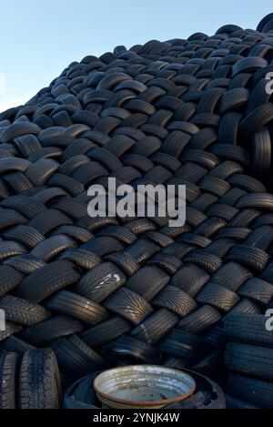 Un mucchio elevato di pneumatici diversi. Pneumatici per auto, camion e motore impilati su un cumulo. Pneumatici usati Foto Stock