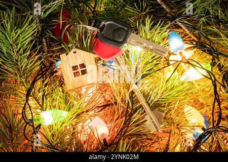 La chiave della casa o dell'appartamento sotto l'albero di Natale. Un regalo per Natale. Alloggi in affitto per celebrare il concetto di vacanze di Capodanno. Foto Stock