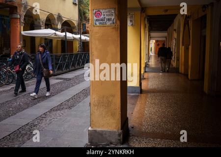 Bologna, Italia. 6 ottobre 2024 - persone che passeggiano attraverso incantevoli portici in un pomeriggio tranquillo Foto Stock