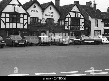 Anni '1970, auto storiche dell'epoca parcheggiate fuori dalla storica vecchia casa pubblica, The White Swan Hotel, Rother Street, Stratford Upon Avon, Inghilterra, Regno Unito. Il cigno bianco esiste dal 1560. Foto Stock