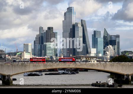 Autobus a due piani che attraversano il Waterloo Bridge sul Tamigi, con i grattacieli della City di Londra sullo sfondo. Waterloo Bridge, Lon Foto Stock