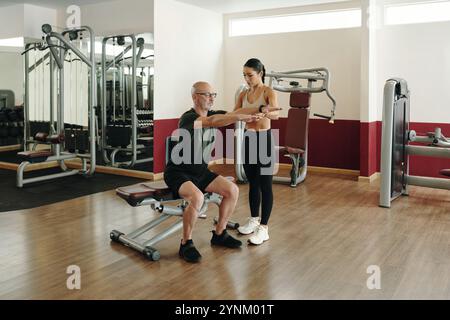 Sessione di allenamento con Personal Trainer nella palestra moderna Foto Stock