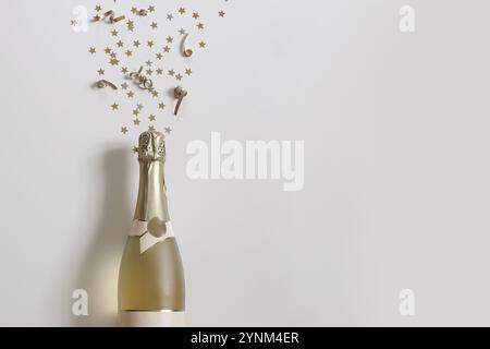 Una bottiglia di champagne spruzza scintillanti stelle dorate su sfondo bianco. Coriandoli scoppiati. Felice anno nuovo natura morta. Matrimonio, compleanno Foto Stock