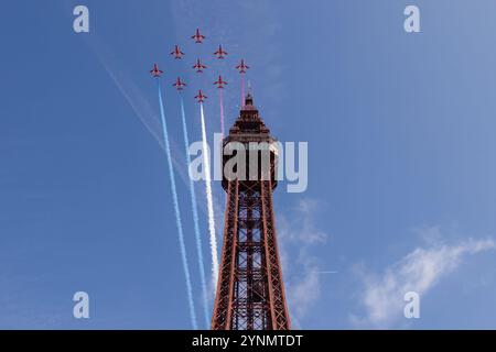 Le frecce rosse, il famoso team di aerobatica del Regno Unito, si esibiscono in un volo mozzafiato sopra l'iconica Blackpool Tower. Contro un cielo azzurro, il loro prec Foto Stock