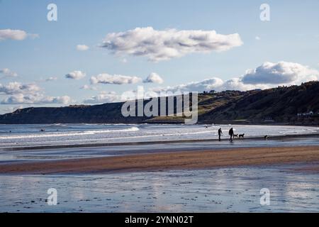 Due uomini con cani camminano a Scarborough Beach. Foto Stock