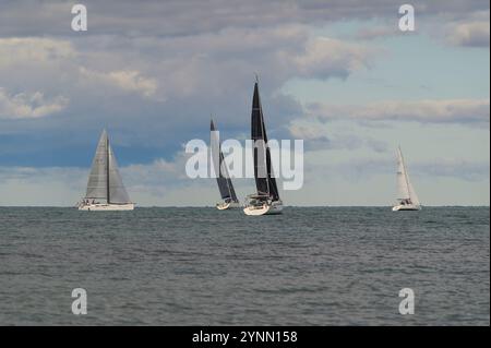 Vista panoramica di numerose barche a vela colorate durante la regata a San Vincenzo, Toscana, Italia. Navigazione competitiva in una giornata limpida Foto Stock