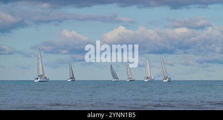 Vista panoramica di numerose barche a vela colorate durante la regata a San Vincenzo, Toscana, Italia. Navigazione competitiva in una giornata limpida Foto Stock
