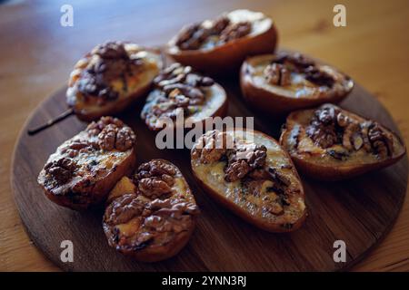 Pere cotte con noci e formaggio blu, che catturano un'atmosfera rustica e confortevole. Foto Stock