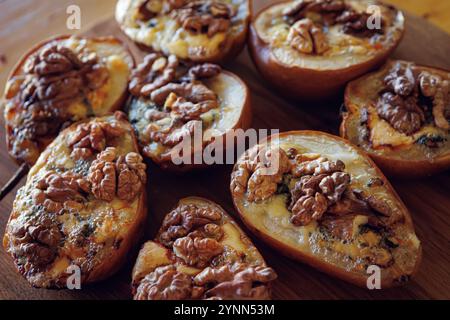 Pere cotte con noci e formaggio blu, che catturano un'atmosfera rustica e confortevole. Foto Stock