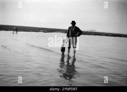 Sir Arthur Conan Doyle, che scrisse i misteri di Sherlock Holmes negli anni '1880 e '90, in vacanza al mare con il suo giovane figlio Denis, intorno al 1910 Foto Stock