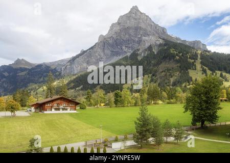 Chalet in legno nel villaggio di Kandersteg, Canton Berna, Svizzera, Europa, alberi d'autunno e panorama delle montagne, Europa Foto Stock