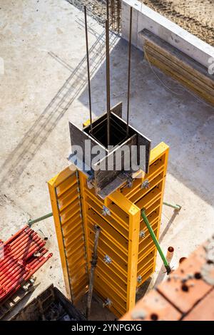 Cassaforma verticale in calcestruzzo in cantiere con barre di rinforzo e struttura in corso Foto Stock