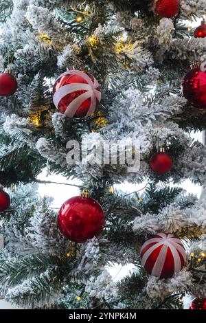 Sfondo cartolina Natale e Capodanno. Modello di vacanza con rami innevati, palle rosse sull'abete, primo piano Foto Stock