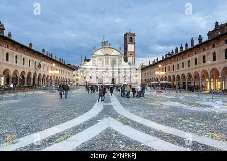 La piazza disseminata di coriandoli di fronte a un edificio storico ornato cattura le festose conseguenze di un evento celebrato. Vigevano, Lombardia. Italia Foto Stock