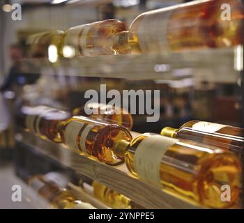 Bottiglie di vino a riposo impilate su scaffali di legno. Foto scattata in un famoso centro commerciale di Berlino Foto Stock