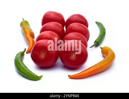 Immagini intere e tagliate di vari peperoncini e pomodori su sfondo bianco. Miscela di pomodori freschi e peperoni. Foto Stock