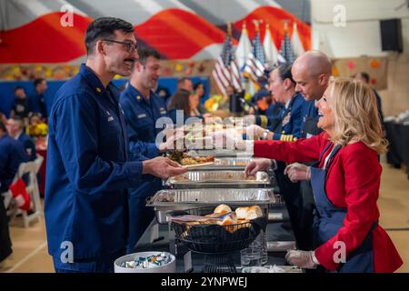 Staten Island, Stati Uniti. 25 novembre 2024. U. La S First Lady Jill Biden, a destra, serve pasti a famiglie militari e ospiti in occasione di un evento "Friendsgiving" presso il settore della Guardia Costiera degli Stati Uniti di New York, 25 novembre 2024, a Staten Island, New York. Crediti: Adam Schultz/White House Photo/Alamy Live News Foto Stock