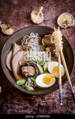 Spaghetti Ramen con bacchette circondati da funghi Foto Stock