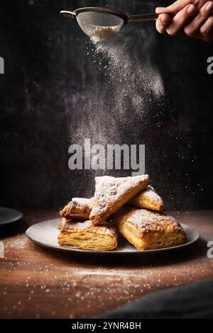 Paillettes di mele con zucchero a velo su superficie in legno Foto Stock